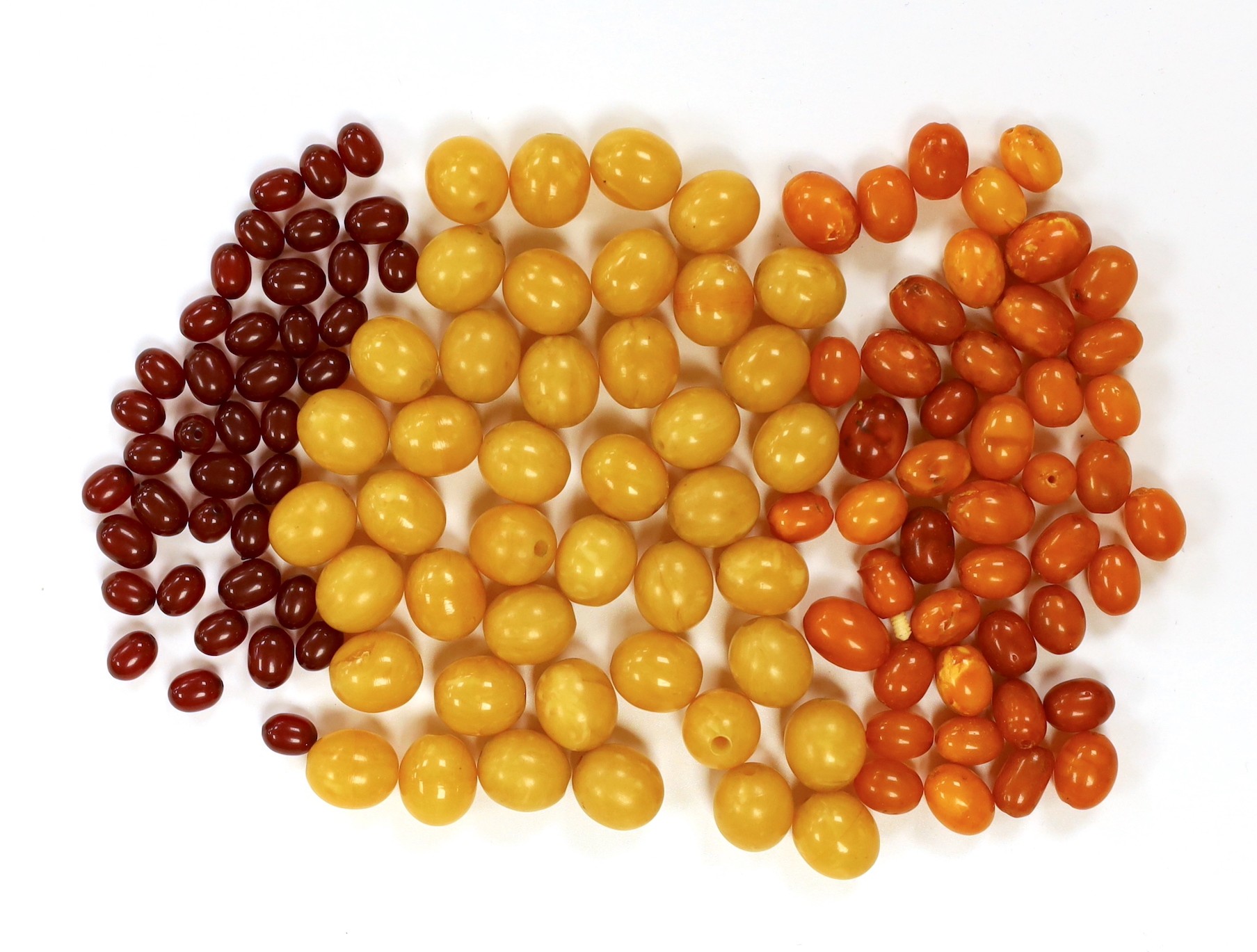 A group of loosed butterscotch amber beads, gross 31 grams, a group of loose yellow amber beads and a group of loose simulated cherry amber beads.